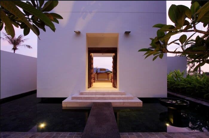 Grand villa entrance with tropical landscaping