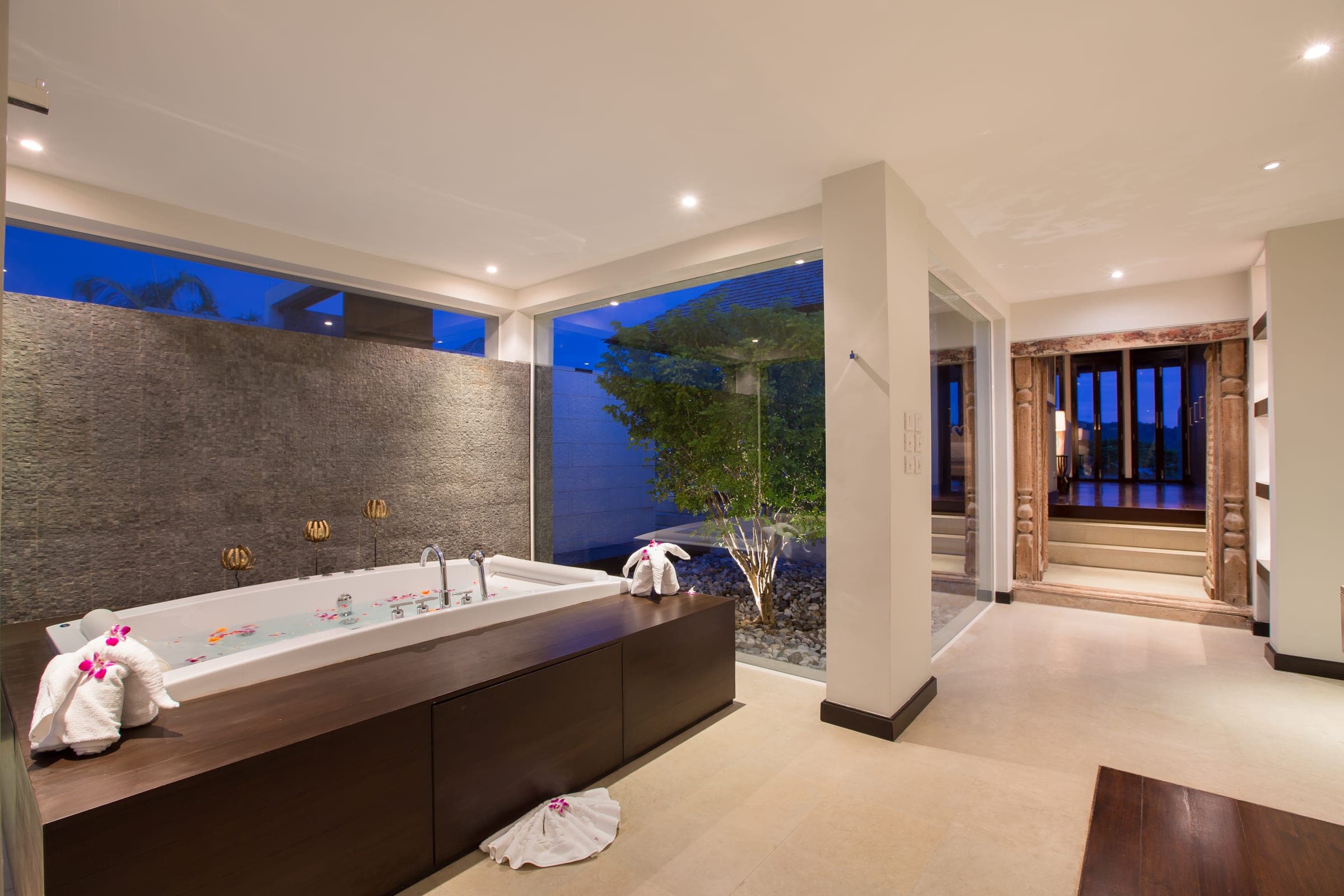 Master bathroom at dusk with jacuzzi bathtub and private garden view
